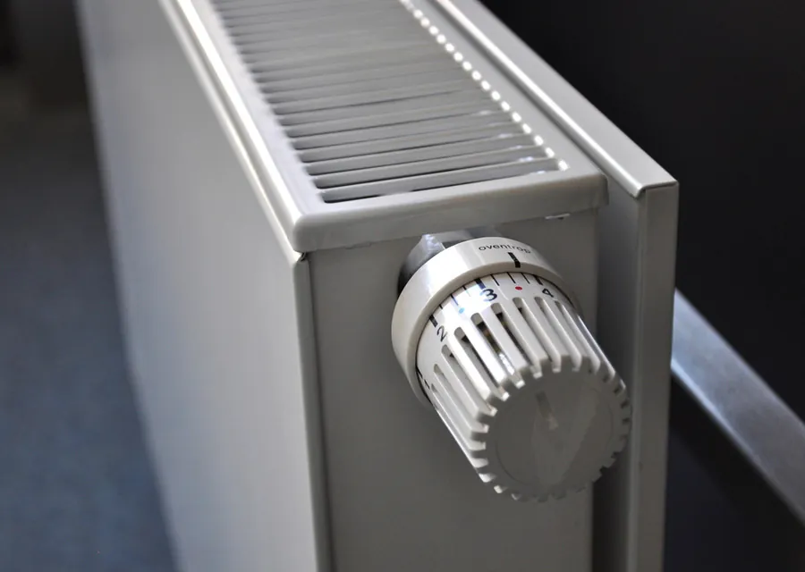 A panel radiator with a thermostatic valve fitted to the pipe at one end.