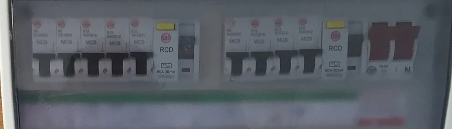A consumer unit with the cover fitted, showing two banks of breakers either side of a pair of RCDs.
